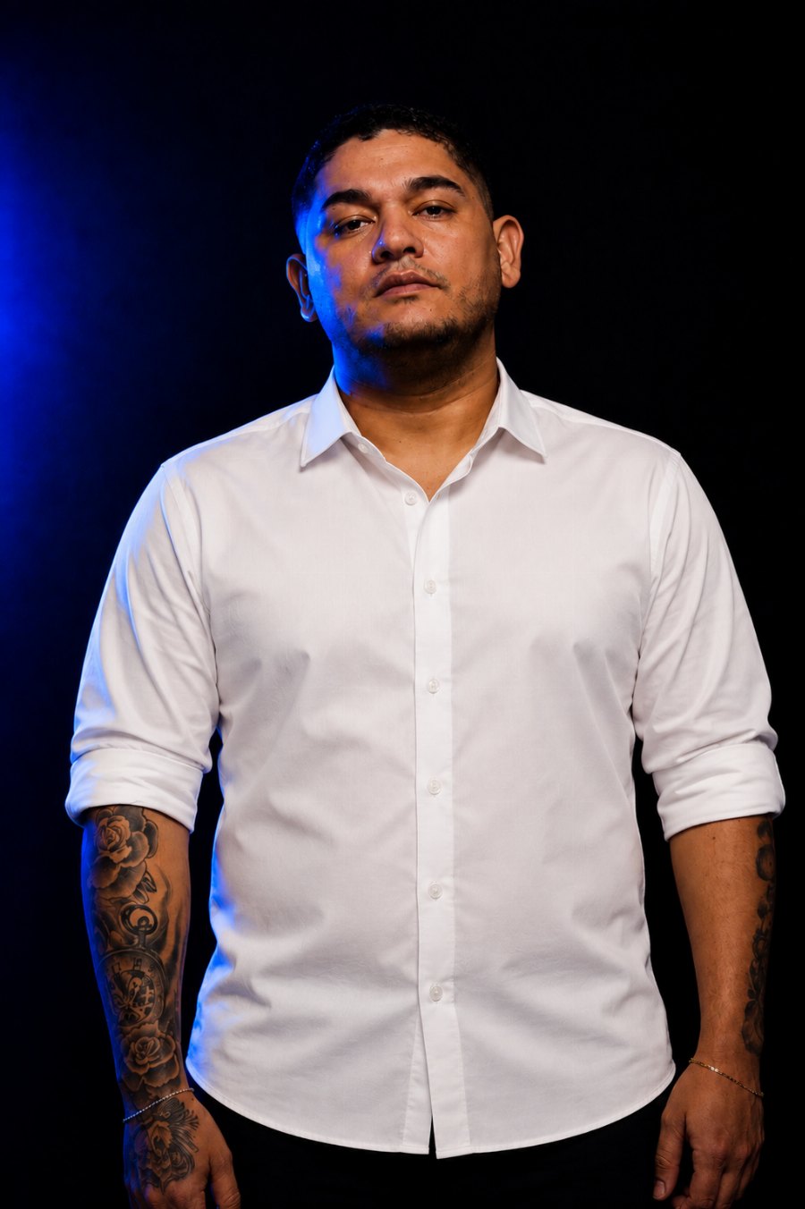 Júnior Lima, fundador do Publish Law, de camisa branca, em fundo escuro com luz azul