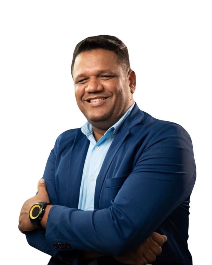 Eliel Primo, sócio do Publish Law, de blazer azul e camisa azul-clara, sorrindo de braços cruzados